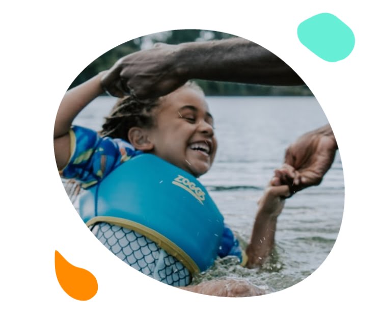 Em bé đang chơi đùa dưới nước với áo phao