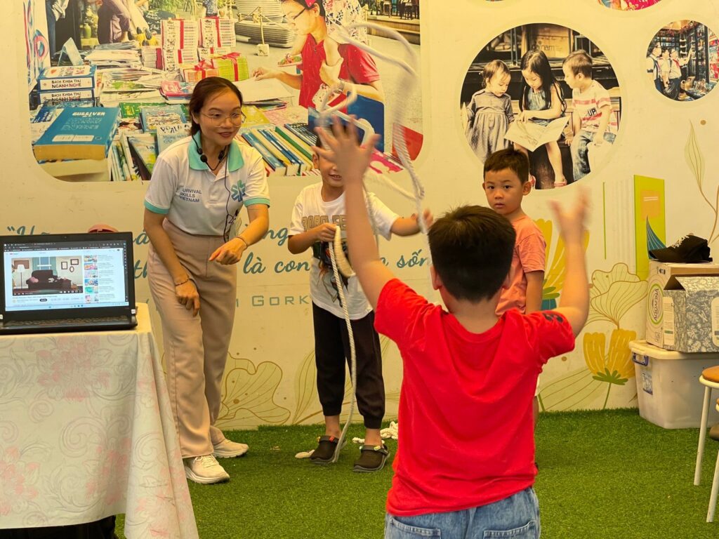 The children are excitedly participating in first aid games such as: coloring to identify dangerous objects, practicing throwing ropes to save drowning people to safety...